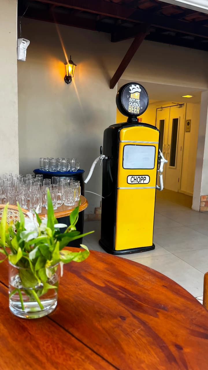 Chopeira bomba de gasolina amarela montada em evento com copos de chopp
